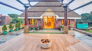 A modern house with a tiled roof, a wooden deck, and a large decorative bowl in the center.