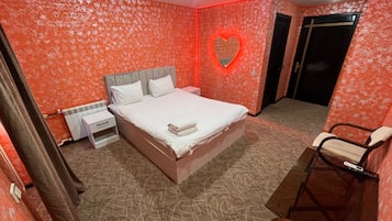 Ein Schlafzimmer mit Bett, Nachttisch und Stuhl.