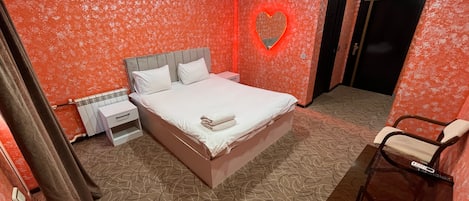 Une chambre à coucher avec un lit, une table de chevet et une chaise.