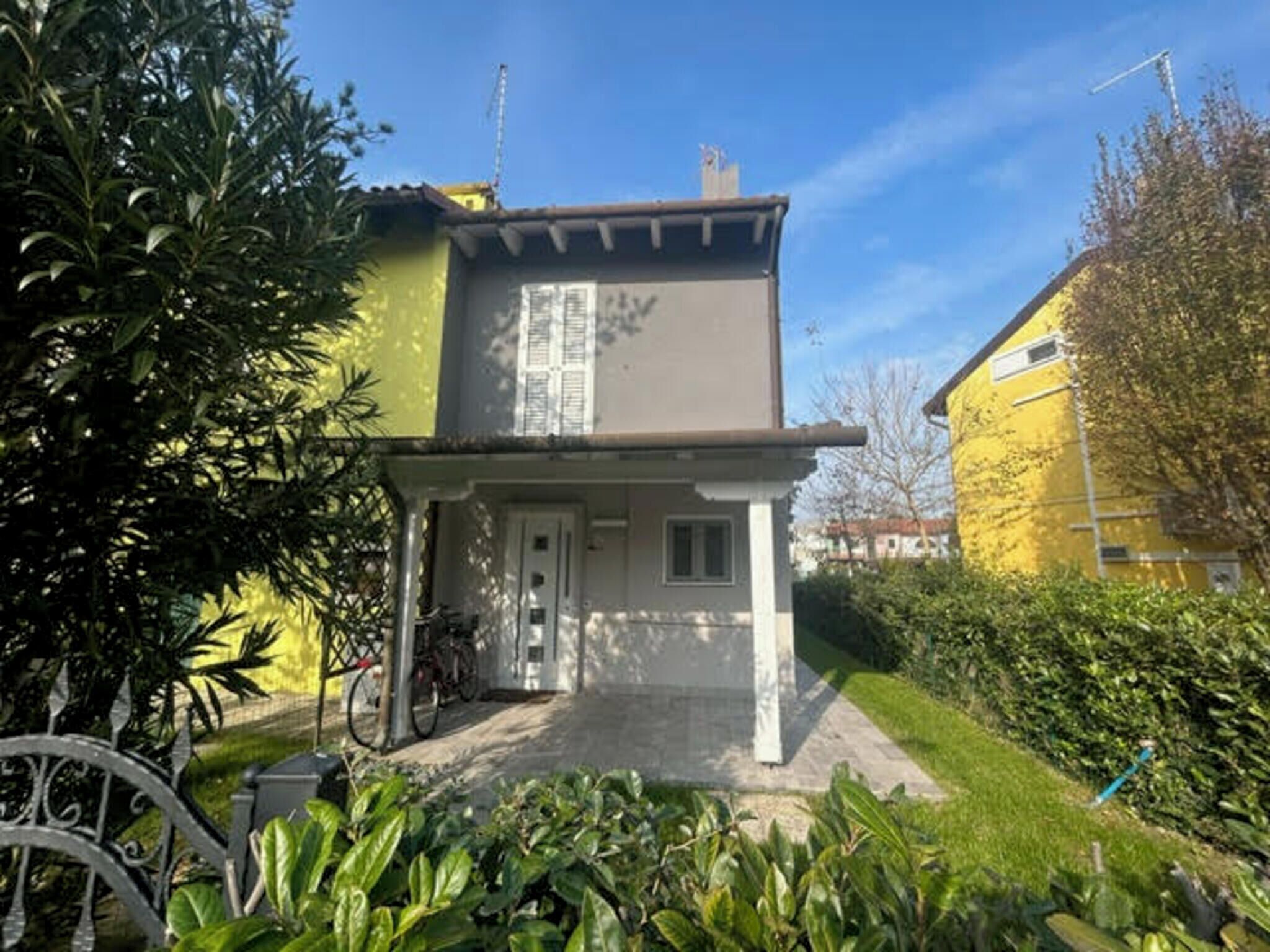 A two-story house with a front porch, a bicycle parked outside, and a well-maintained garden.