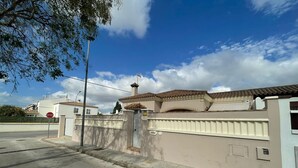 A gated residential area with a stop sign, a paved road, and a clear sky. - Villa Bolet        . (Chiclana de la Frontera)
