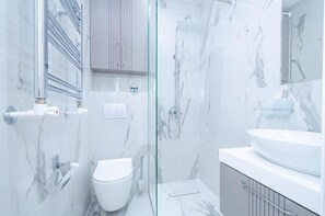 A modern bathroom with a glass shower enclosure, a white toilet, and a large sink. - La Torre Hotel (Yerevan)