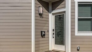 A house with a beige exterior, a glass door, and a small porch area. - Downtown Escape - 5 blocks to Riverwalk (Wilmington)