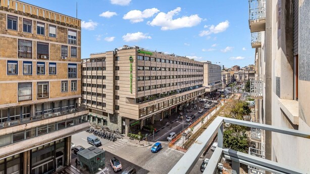 Un edificio de varios pisos con una planta baja comercial y pisos superiores residenciales.