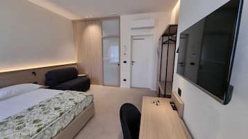 Habitación triple Deluxe, baño privado | Minibar, caja fuerte, escritorio y espacio para trabajar con un portátil
