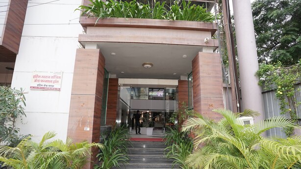 A hotel entrance with a staircase leading to the lobby, surrounded by potted plants. - Hotel Grand Maratha  (Nanded)
