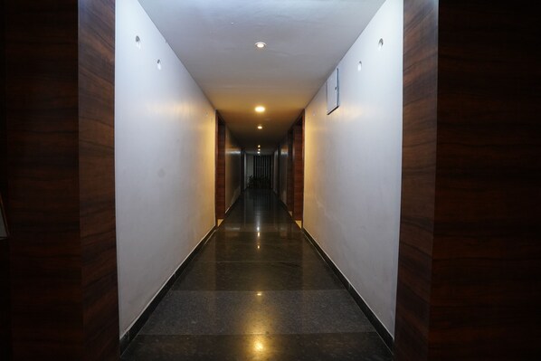 Un pasillo largo y estrecho con paneles de madera en las paredes y un suelo brillante y reflectante.
