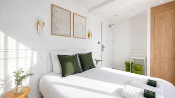 Un dormitorio moderno con una cama grande, un armario de madera y una ducha.