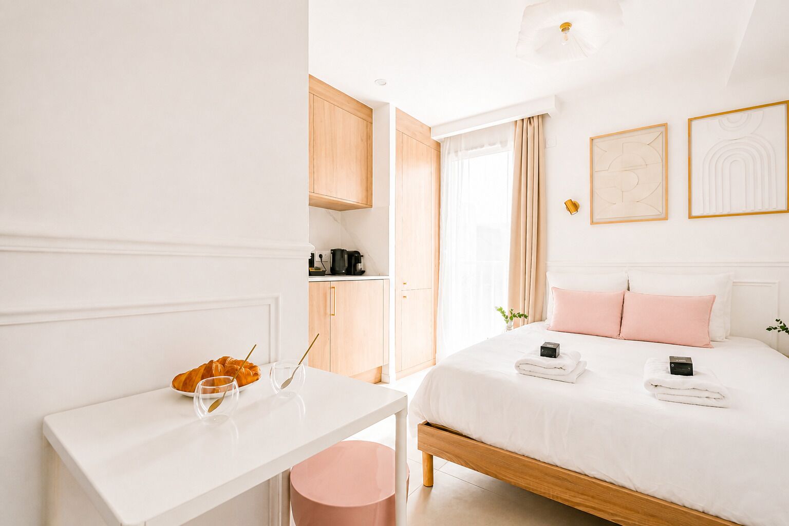 A hotel room with a bed, bedside table, and a desk with a chair.