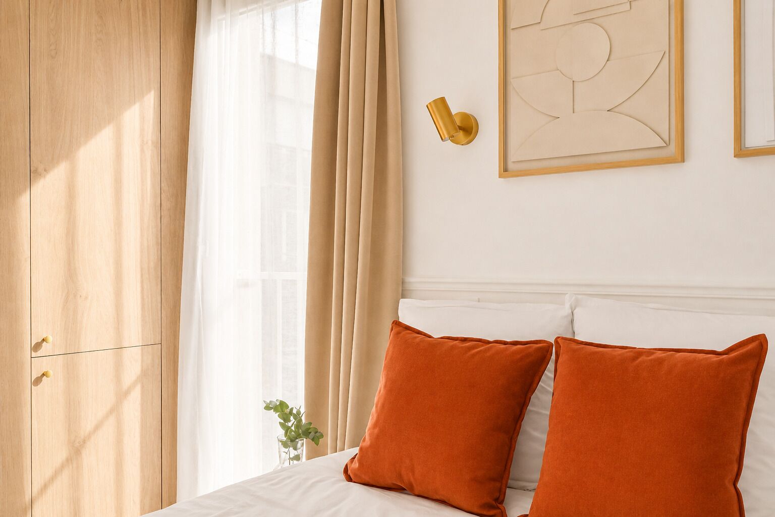 Quarto com cama, cortinas bege, luminária fixada na parede e obra de arte abstrata emoldurada.