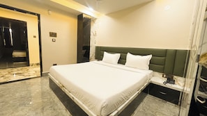 A modern hotel room with a large bed, a nightstand, and a marble floor.