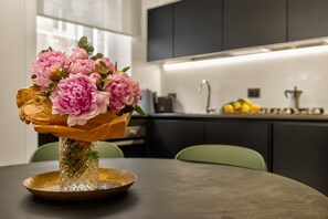 Una mesa de comedor con un florero y un frutero.