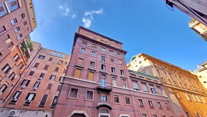 Un edificio de varios pisos con una entrada central destacada y numerosas ventanas.