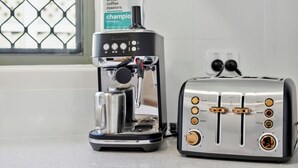 A Breville espresso machine and a Breville toaster on a kitchen counter.
