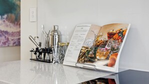 Eine Bar mit einer Speisekarte, Cocktailgläsern und Bartisch-Ausrüstung auf einer weißen Arbeitsplatte.