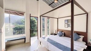 A four-poster bed with a view of greenery outside. - Aspen Adventures Camp by Aspen (Rishikesh)
