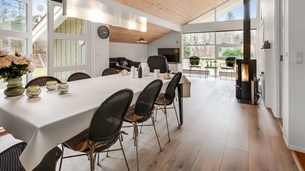 Une cuisine moderne dotée d’un grand îlot central, d’un plafond en bois et de grandes fenêtres.