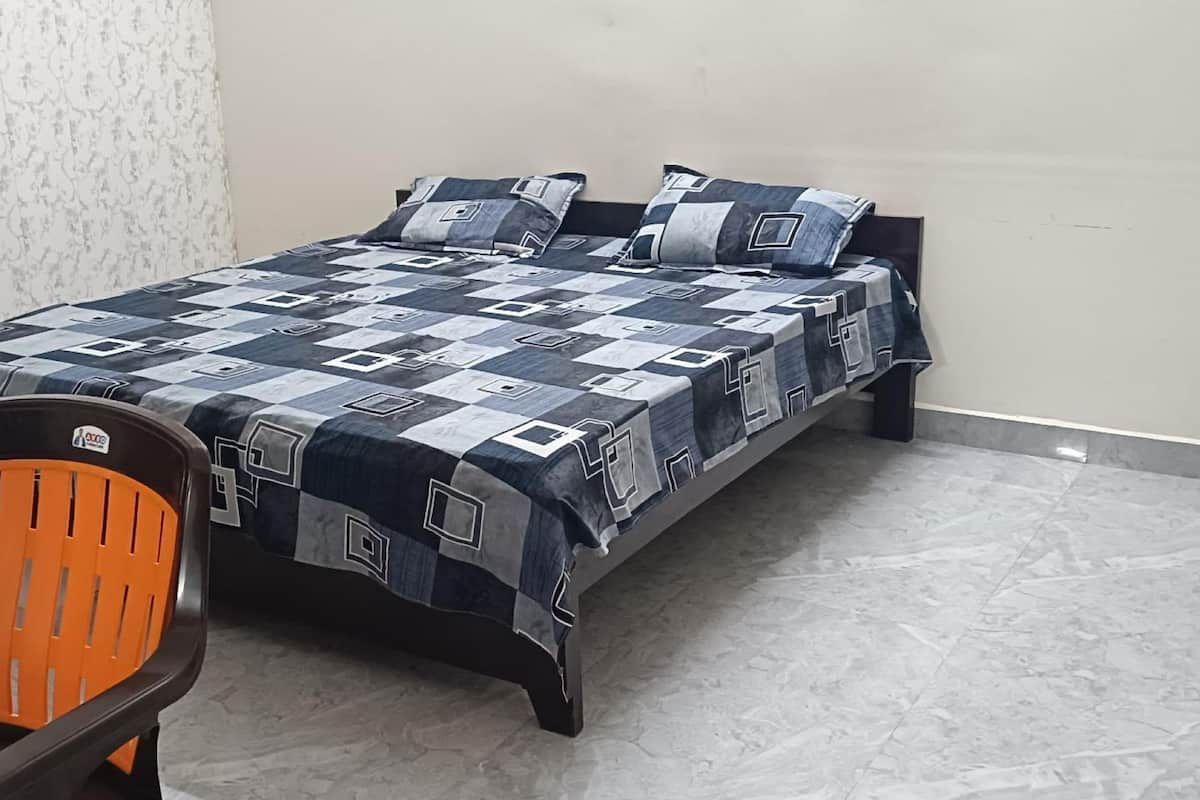 Une chambre à coucher avec un lit, une chaise et un mur décoré de motifs.