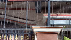 A building with a red and white signboard, a metal gate, and a brown structure with a sign. - Hariom Home Stay By GRB (Faizabad)