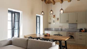 Una cocina moderna con vigas de madera, una mesa de comedor y un sofá.