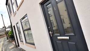Un edificio residenziale con una porta d'ingresso scura, una piccola finestra e il numero '1' ben visibile sulla porta.