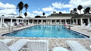 Ein Pool mit Liegestühlen und Palmen.