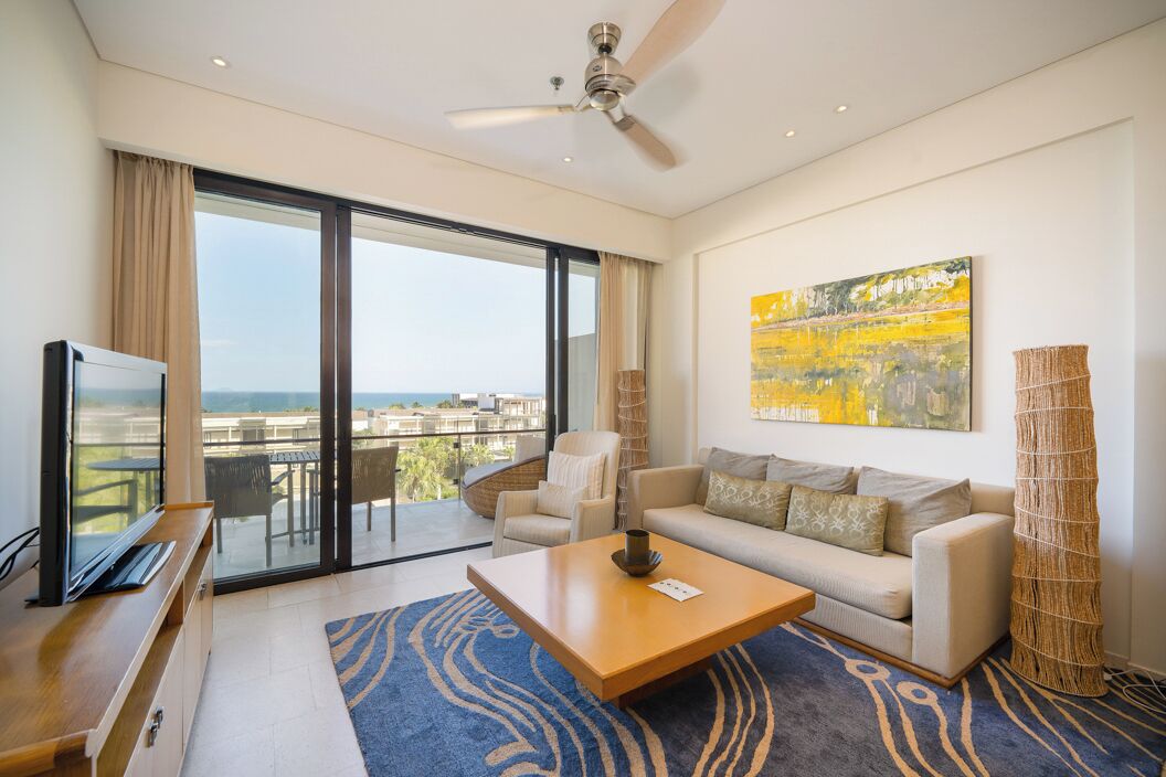 A modern living room with a sofa, coffee table, and a television.