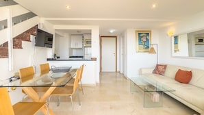 A modern apartment with a dining area, kitchen, and living room.
