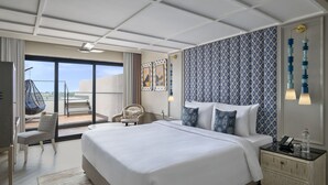 Habitación de hotel con una cama grande, una silla, una mesita de noche y vistas al exterior.
