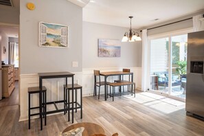 Una cocina con comedor, piso de madera y vista al exterior.