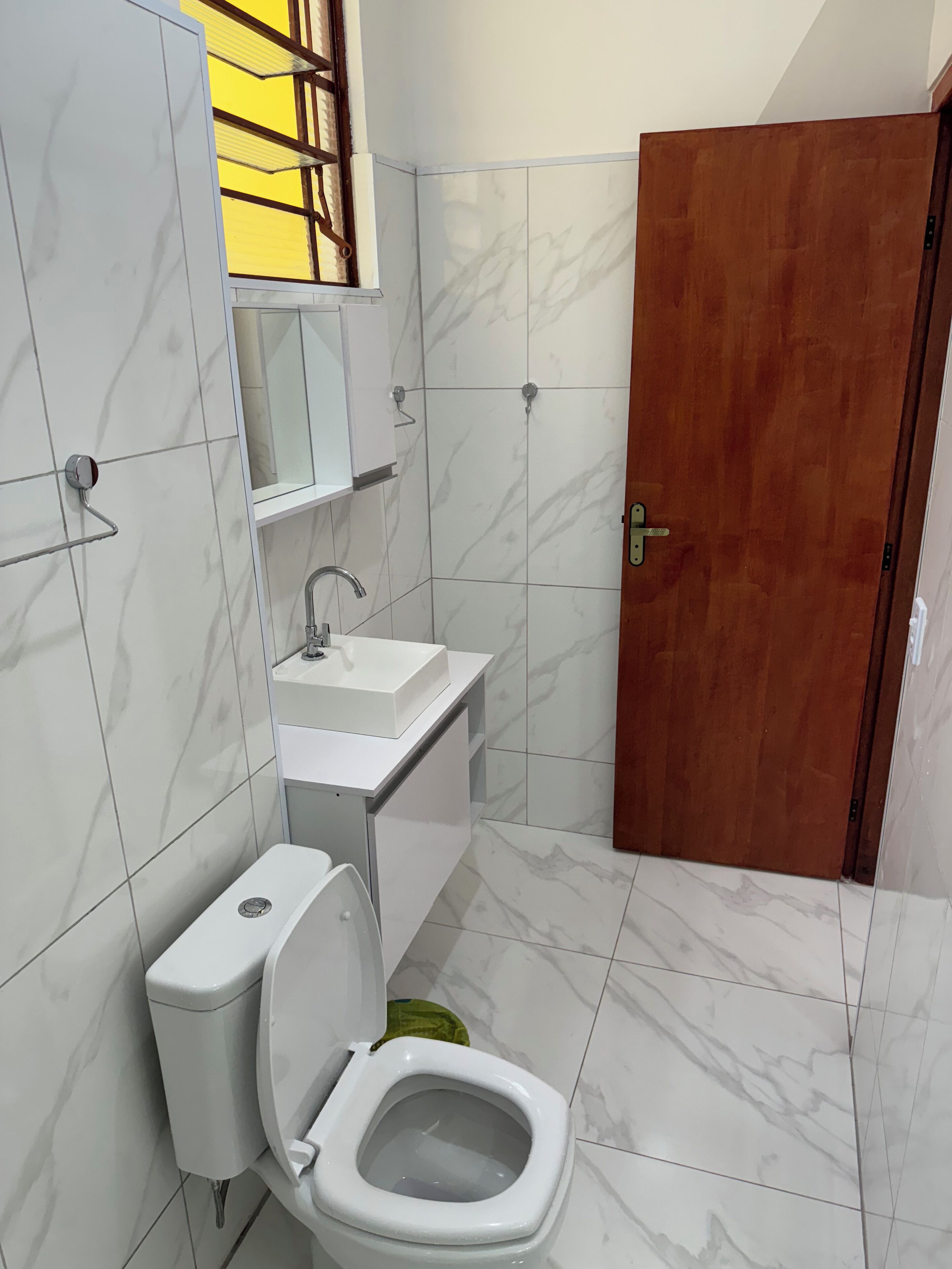 Un baño con inodoro, lavamanos y espejo.