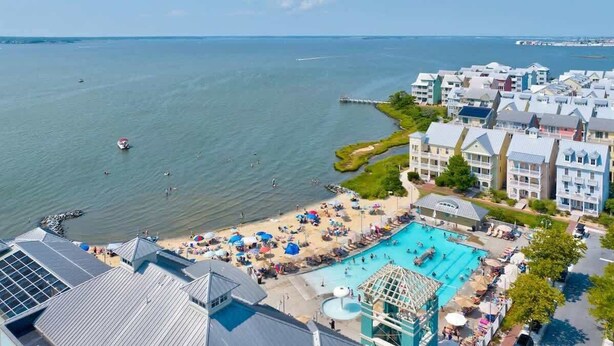 Un resort costero con piscina, playa y vista al océano.