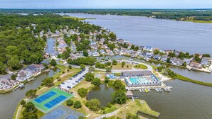 An aerial view of a lakeside community with residential houses, a tennis court, and a swimming pool area. - Ocean Pines Hideaway (Ocean Pines)