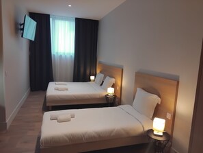 A hotel room with two beds, each with a bedside lamp and a TV mounted on the wall. - APPART HOTEL RESIDIS PARAY - ORLY (Paray-Vieille-Poste)