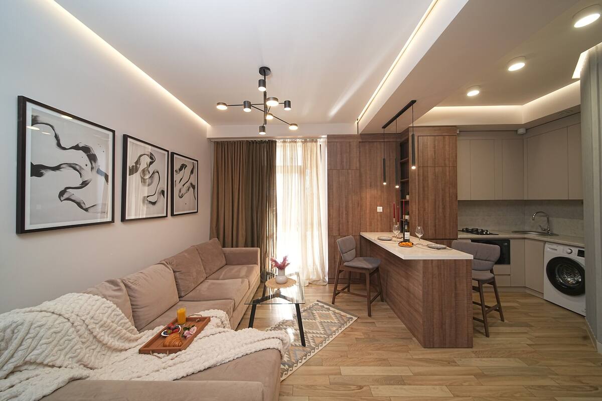 A modern living room with a sofa, coffee table, and artwork on the wall.