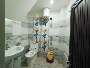 A bathroom with a sink, toilet, and shower. - The Royal Green Residency (Varanasi)