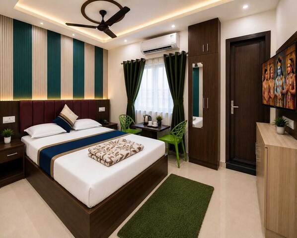 A modern hotel room with a large bed, a desk, a chair, a ceiling fan, and a TV on the wall.
