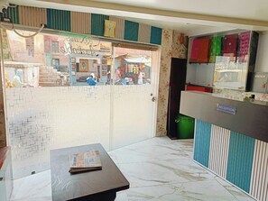 Un'area di accoglienza con reception, orologio e vista sulla strada.