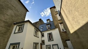 Eine enge Straße mit Gebäuden, die viele Fenster und Balkone haben.