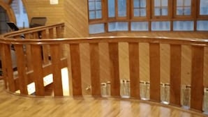 Ein Holzinnenraum mit einer geschwungenen Geländer, einer Treppe und großen Fenstern.