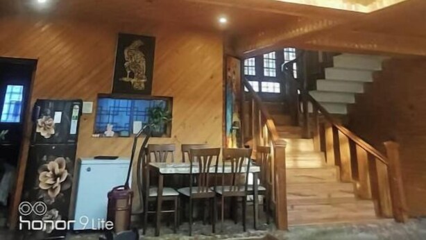 Ein mehrgeschossiges Holzinnere mit Essbereich, Treppe und dekorativen Elementen.