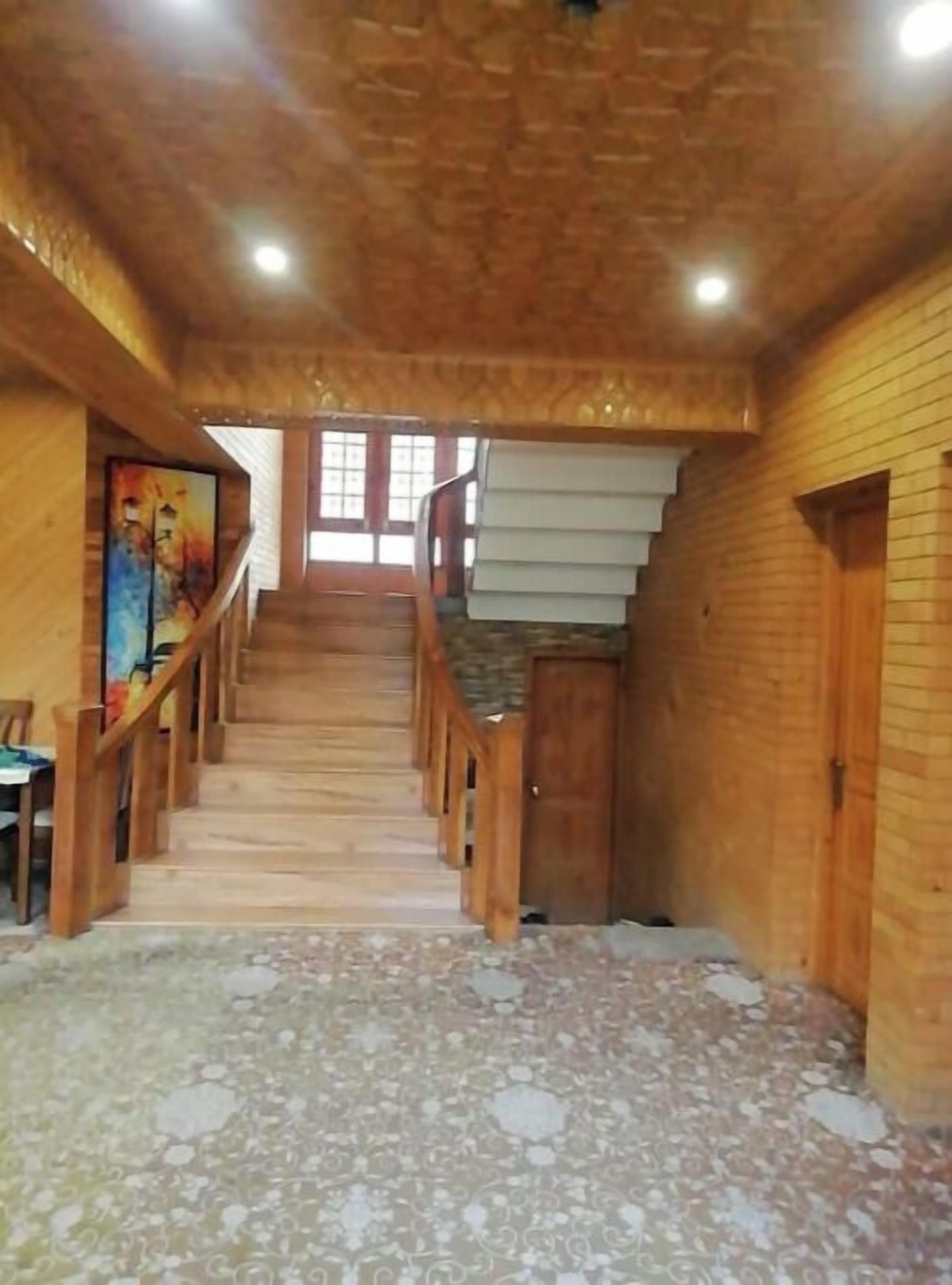 Eine Holztreppe mit Geländer führt zu einer Tür oben.