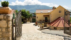 A cobblestone street leading to a traditional building with a tiled roof, stone walls, and a gate. - Authentic Dalmatian Hillside Escape With Pool, Sauna & BBQ (Sestanovac)