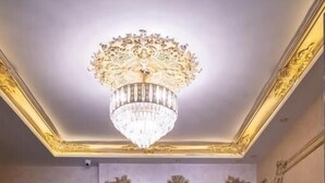 A luxurious lobby with a grand chandelier, ornate wall decorations, and a blue sofa set. - Settle Inn Janoub Apartments (New Cairo)