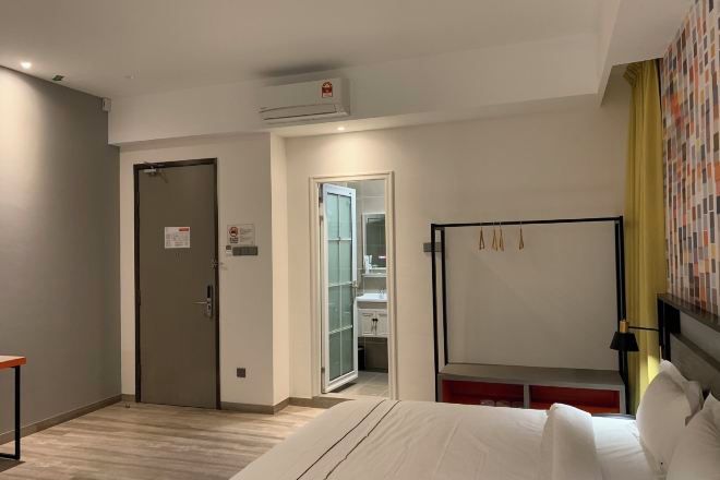 Une chambre d’hôtel équipée d’un lit, d’un bureau, d’une armoire, d’une porte et d’un appareil de climatisation.