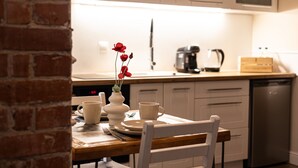 Ett kök med vita skåp, en kaffebryggare och en diskmaskin.
