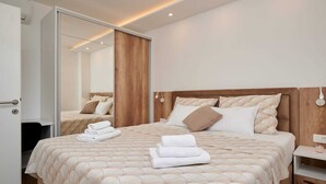 Ein modernes Schlafzimmer mit einem großen Bett, einem Holzkopfende und einem Spiegel.