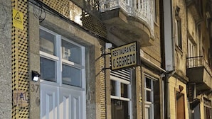 A street with buildings, including a restaurant named "O Segredo" with a sign above the entrance. - Rooms4you 2 in historic center of Braga (Braga)