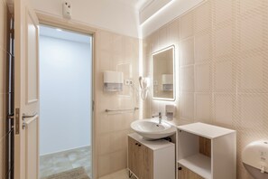 Un bagno moderno con lavabo, specchio e porta asciugamani.