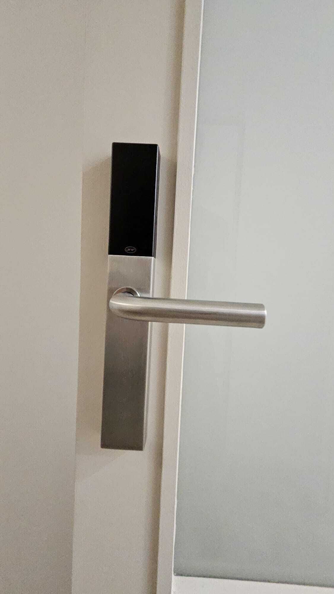 A door with a modern electronic lock and a metallic handle.